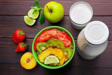 Oatmeals in green plate decorated with slice of strawberry, kiwi