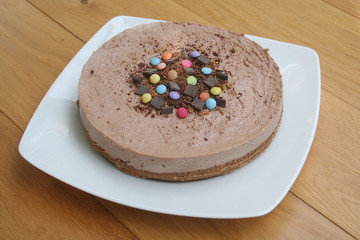 cheesecake al cioccolato su piatto su tavolo di legno