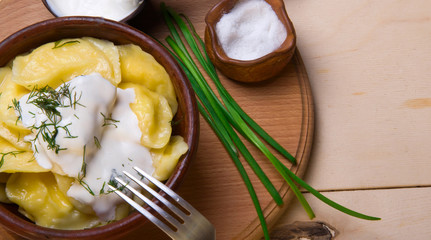 Vareniks  with sour cream - national ukrainian cuisine. wooden s