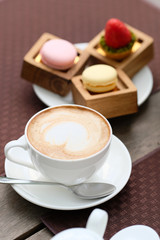 Cup of cappuccino and macaroons