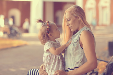 mom with a little girl on a park bench