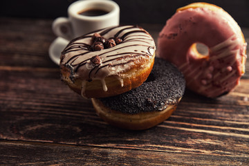 fresh donut with coffee on wooden table with napkin, spoon and c