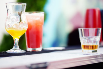 Bartender preparing a cocktail with yellow and red syrup