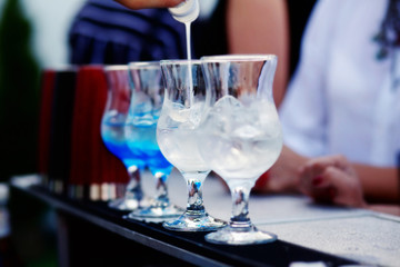 Bartender preparing a cocktail with blue syrup