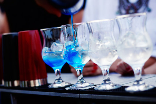 Bartender preparing a cocktail with blue syrup