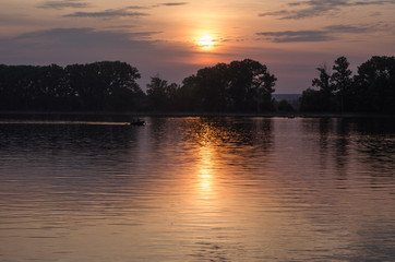 Fototapeta na wymiar Beautiful bright cloudy sunset above the lake.