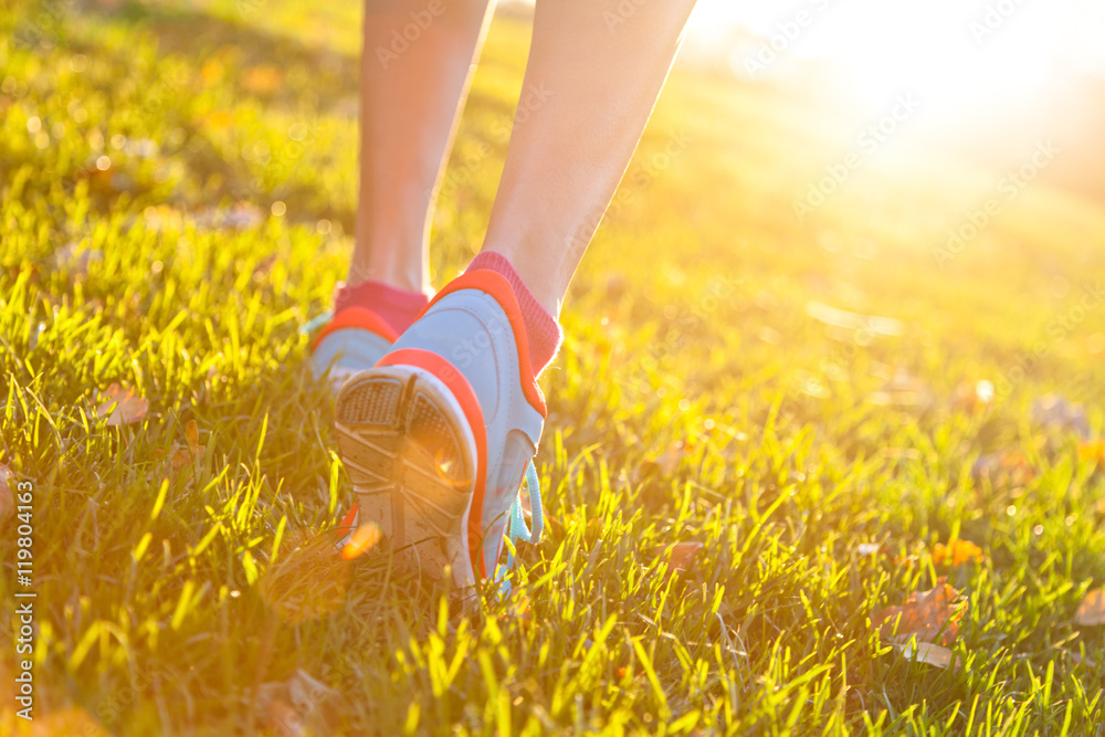 Wall mural close up of feet of a runner running in grass