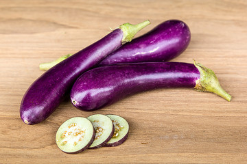 eggplant and slices on hardwood table