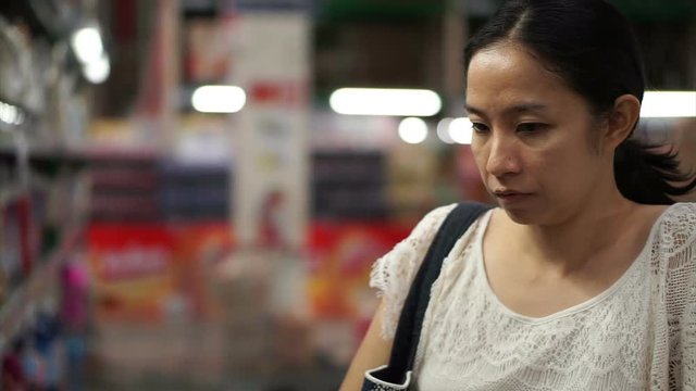 Asian girl, woman walking, looking and shopping snacks in supermarket isle