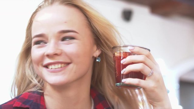 EXTREME CU portrait of a girl having a drink in a cafe