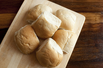 Six tasty buns on wooden board