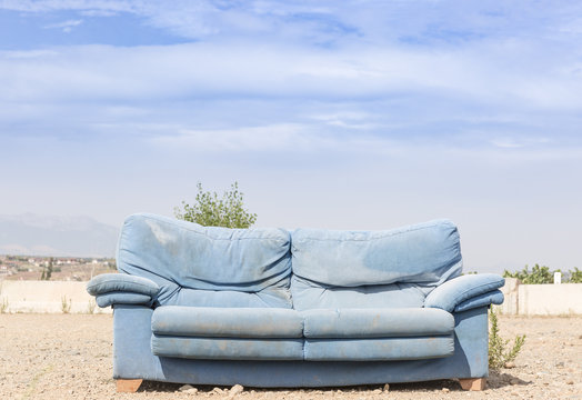 a blue sofa in the outdoors against a blue background