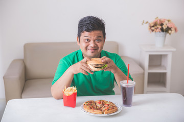 obese man eating junk food