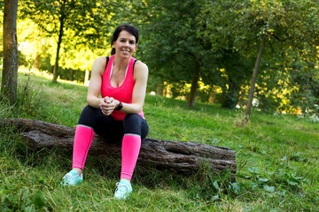 fitness girl sitting on a log having a rest