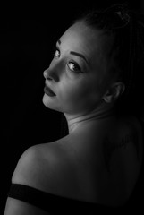 Obraz premium Studio portrait of young beautiful girl on dark background. black and white