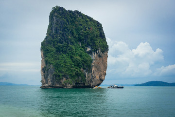 Naklejka premium Cliff on small island and tourist boats in Krabi, Thailand