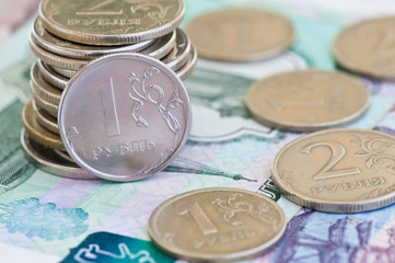 rubles coins against background of 1000 and 500 rubles banknotes