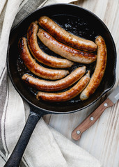 Fried sausages in a cast iron frying pan 