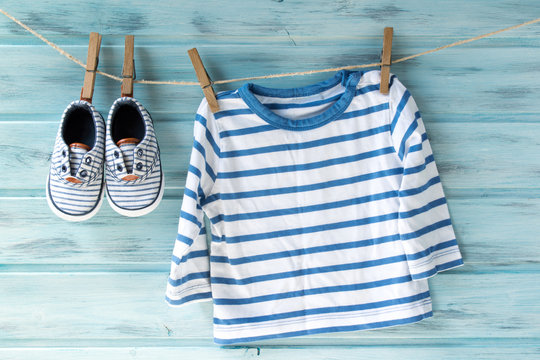 Baby boy striped shirt and baby shoes on a clothesline