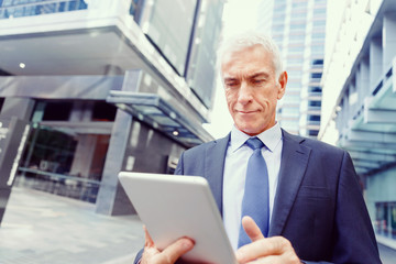 Senior businessman holding touchpad 