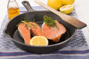 scottish salmon steak with lemon, thyme and rosemary in a cast i