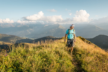 Mountaineer walking over a ridge in the evening light