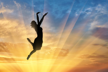 Fototapeta na wymiar Happy woman jumping at sunset