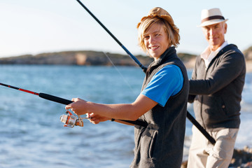 Senior man fishing with his grandson