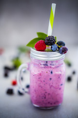Delicious berry smoothie made with fresh ingredients on light background.
