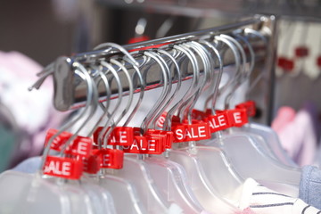 Kleiderständer mit Kleiderbügeln und Sale-Schildern
