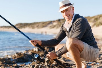 Senior man fishing at sea side