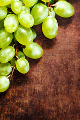 ..Grapes harvest. White  grapes bunch over wooden  background. G