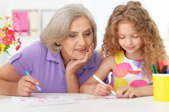 Grandmother with her cute  granddaughter  drawing