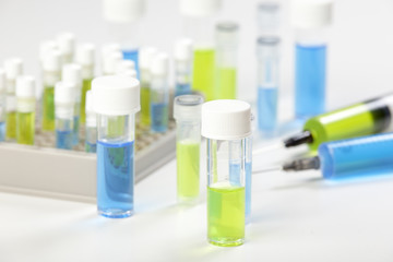 Syringe's and vials containing blue and green fluids