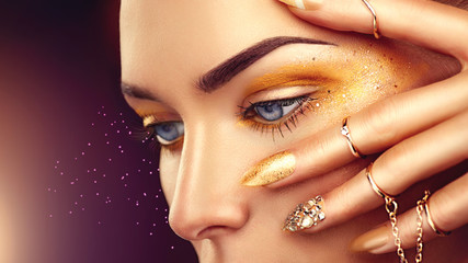 Beauty fashion woman with golden makeup, gold accessories and nails
