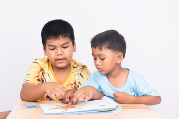 Two little boy play clay on book on white background