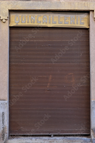 Quincaillerie. Magasin au rideau de fer rouillé fermé.\ Quincaillerie. Magasin au rideau de fer rouillé fermé.\