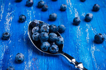 Ripe blueberries on the wooden background