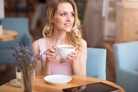 Cute young woman drinking coffee