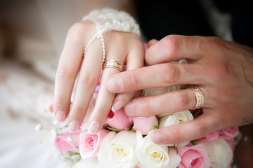 Hands of the groom and the bride with wedding rings and a weddin - 119823979