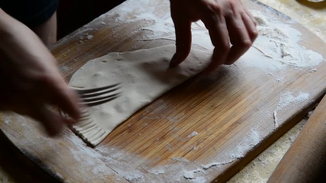 Housewife making chebureks from dough and sausage meat