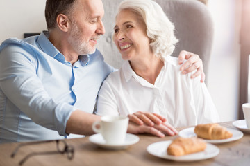Joyful loving couple sitting at the table