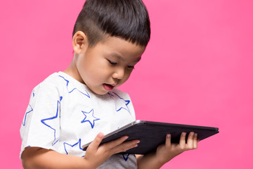 Asian little boy looking on tablet computer