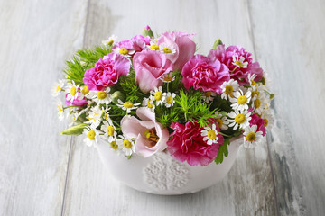 Floral arrangement with pink eustomas, carnations and chamomile