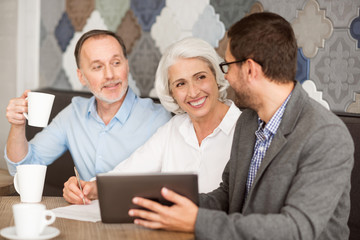 Cheerful senior couple talking with sales manager
