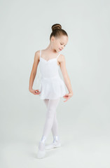 A little adorable young ballerina poses on camera