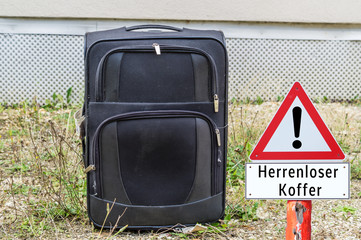Achtung Schild Herrenloser Koffer