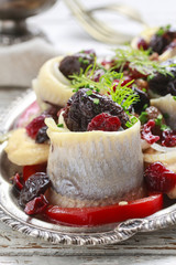 Pickled herring rolls with vegetables and dried fruits