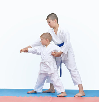 Brother with a blue belt teaches the brother with a white belt to beat the punch arm