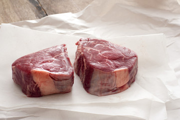 raw joints of beef on butchers paper